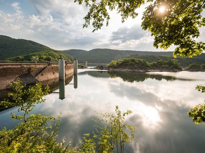 Holiday in the Eifel region with kids: action guaranteed Reservoir with dam and green hills on a sunny day
