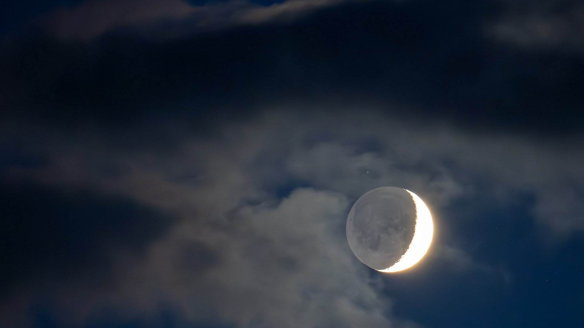 Sternenpark Eifel erleben – Urlaub unter dem Sternenhimmel Zunehmender Mond teilweise von Wolken umgeben am Nachthimmel