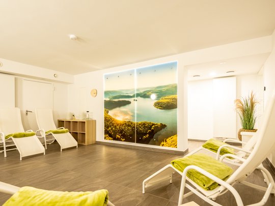 Wohnung mieten in Gemünd? Da haben wir was für Sie! Ruheraum mit Liegestühlen und Landschaftsfoto an der Wand