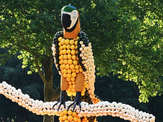 Herbst und Winterzauber in der Eifel genießen Bunte Skulptur eines bärtigen Mannes mit grüner Kappe und ausgebreiteten Armen im Park