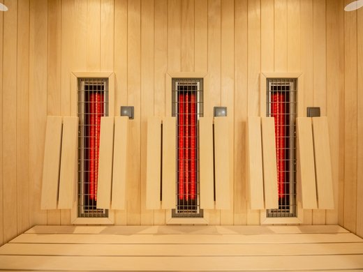 A holiday apartment in the Eifel region with a sauna and gym Infrared heating elements on a wooden sauna wall with wooden benches