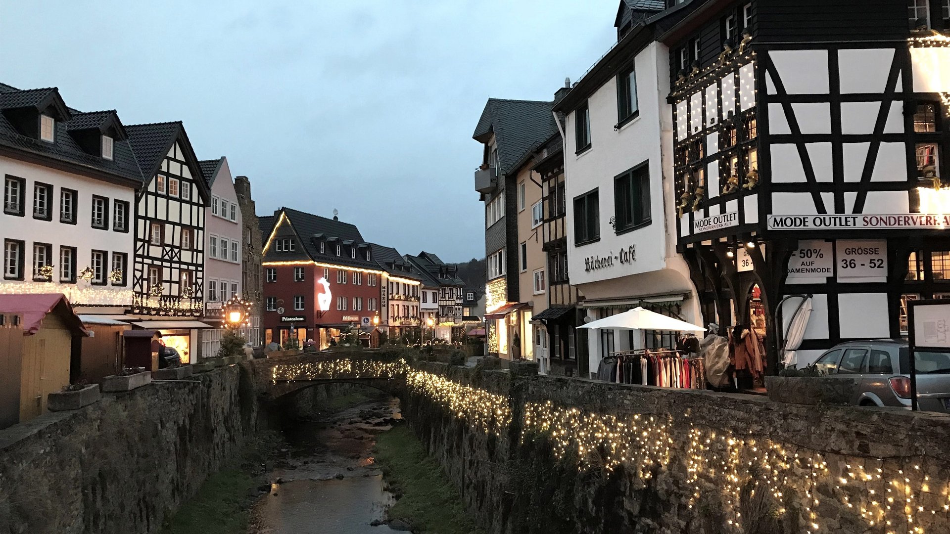 Eifel-Urlaub: Weihnachtsmärkte der Region Abendliche Altstadt mit beleuchtetem Bach und Fachwerkhäusern